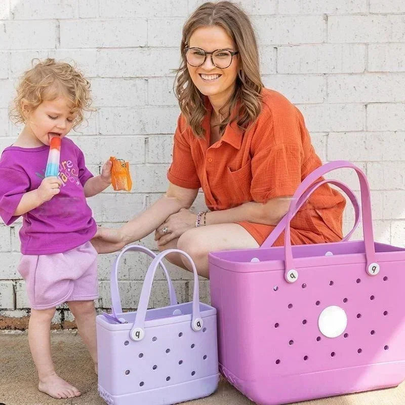 Woman and child with colorful bags against a white brick wall