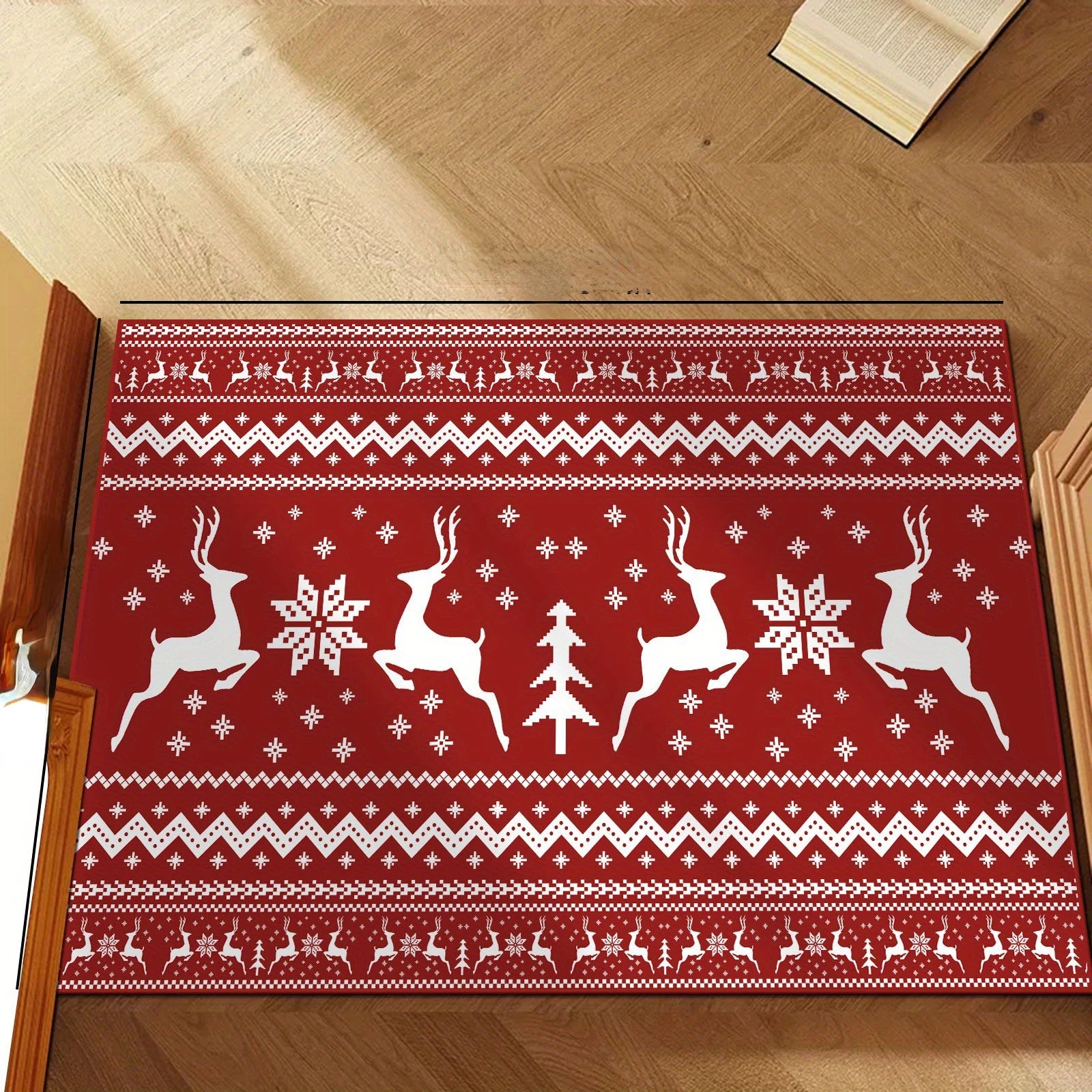 Red Christmas rug with reindeer and Christmas tree design placed near slippers on wooden floor.