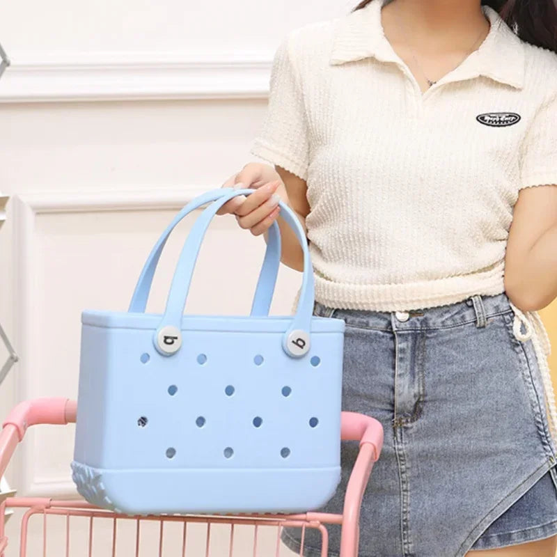 Person holding a light blue handbag with a white background