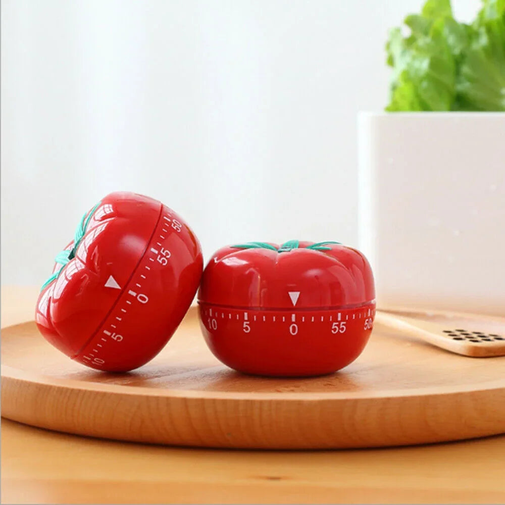Mechanical tomato kitchen timer on wooden table